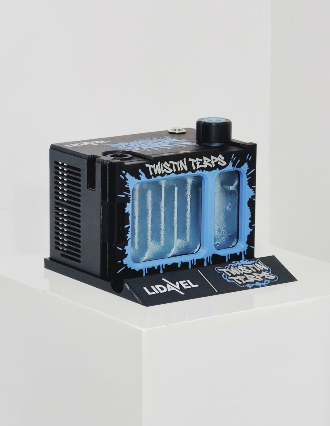 The Box V2 — TwistinTerps × Lidavel Artist Series, three-quarter view on a white plinth with the Lidavel × TwistinTerps card